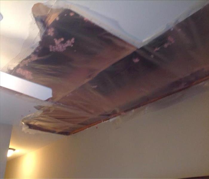 plastic sheeting over water damaged and opened ceiling